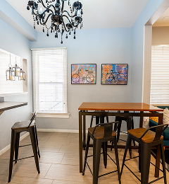 Communal dining nook with chandelier and bike-themed art